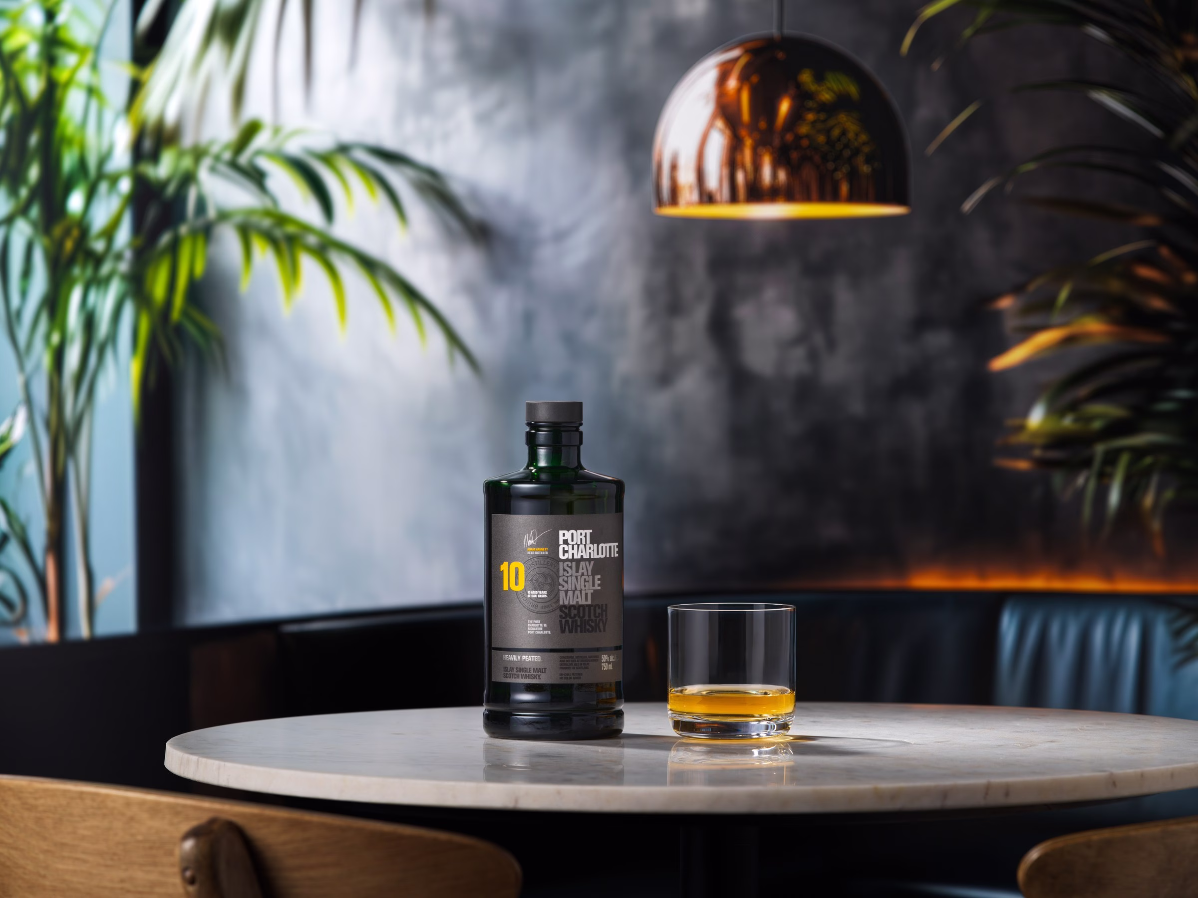 Bruichladdich Port Charlotte 10-Year peated single malt Scotch served neat alongside the bottle