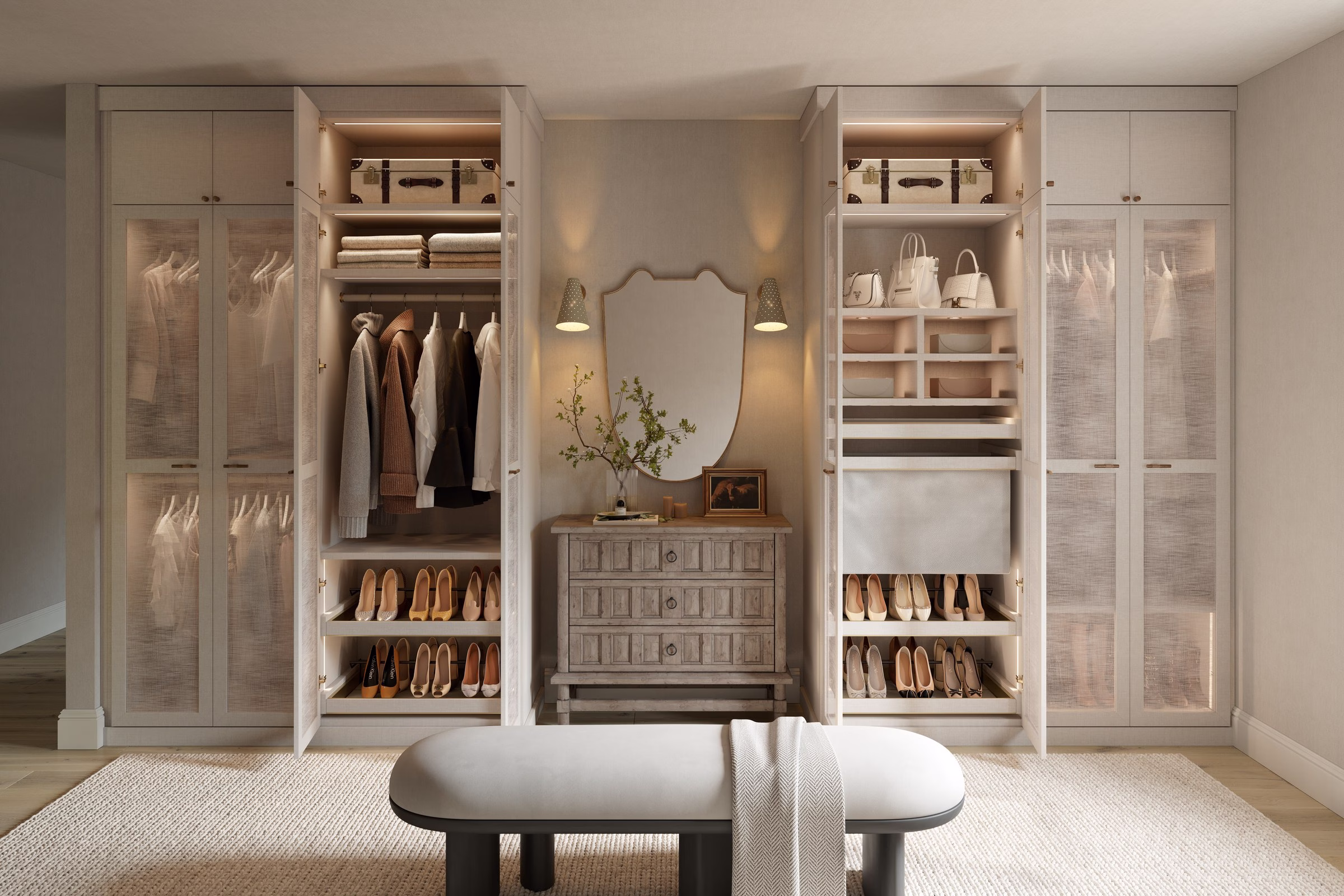 California Closets Traditionalist walk-in primary closet with creamy white cabinetry, arched mirror, and a stone-topped chest