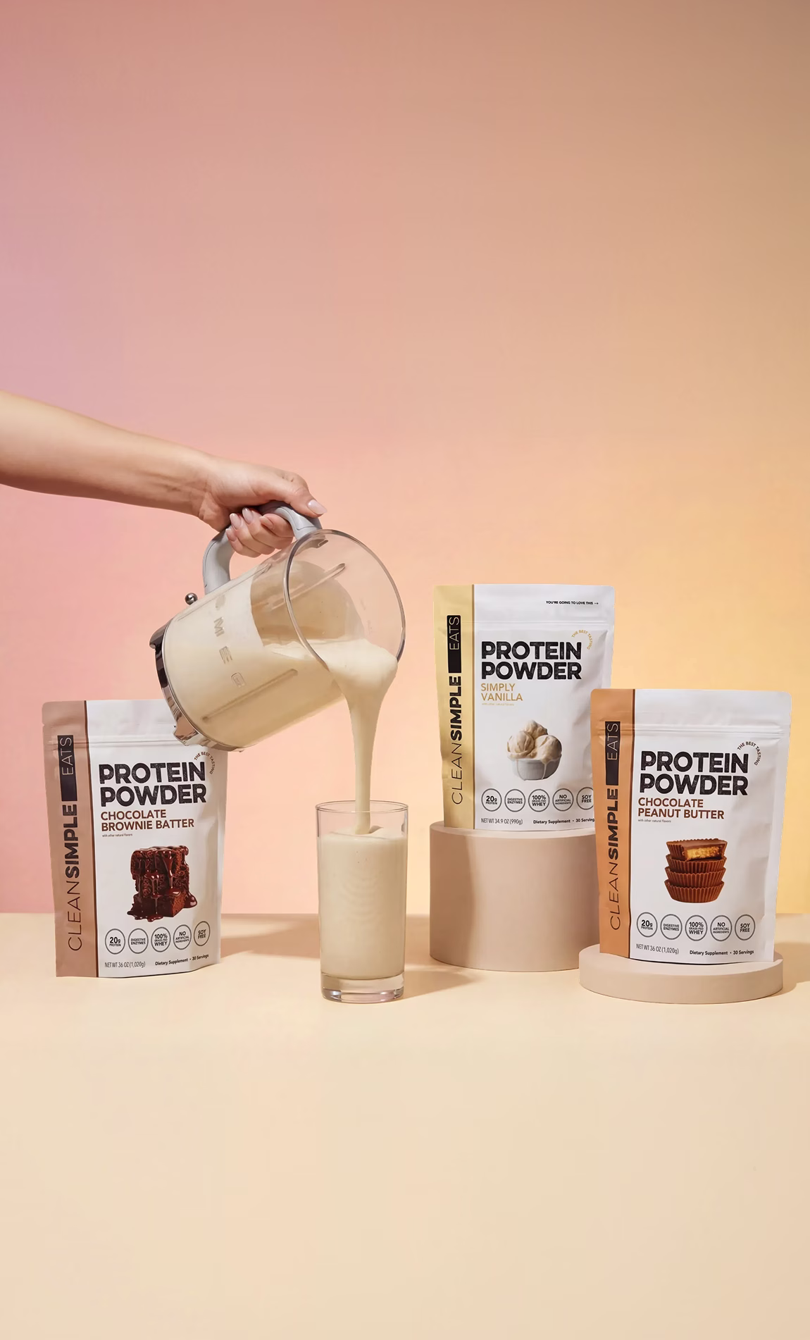 Clean Simple Eats chocolate brownie batter protein shake mid-pour with the powder container beside the glass