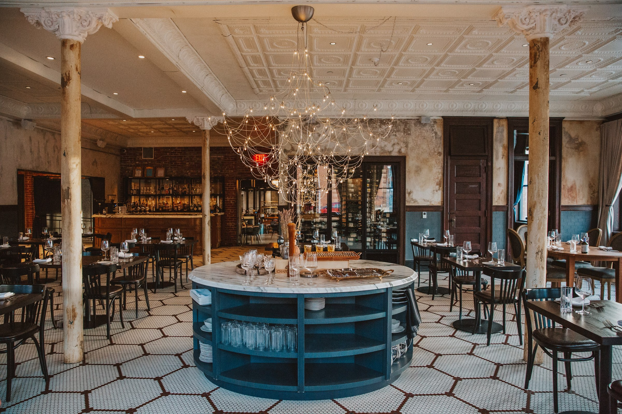 Crossroads Hotel Lazia Italian restaurant interior with red-trimmed windows and tin-ceiling dining room