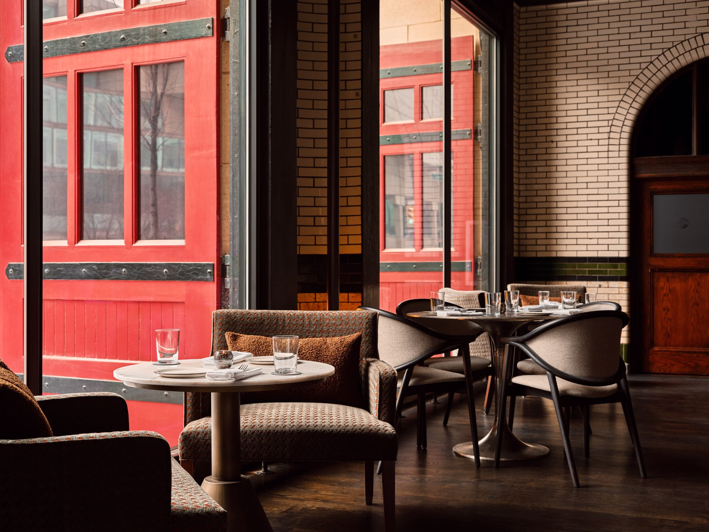 Detroit Foundation Hotel Apparatus Room restaurant booth with red-framed windows and brick archway
