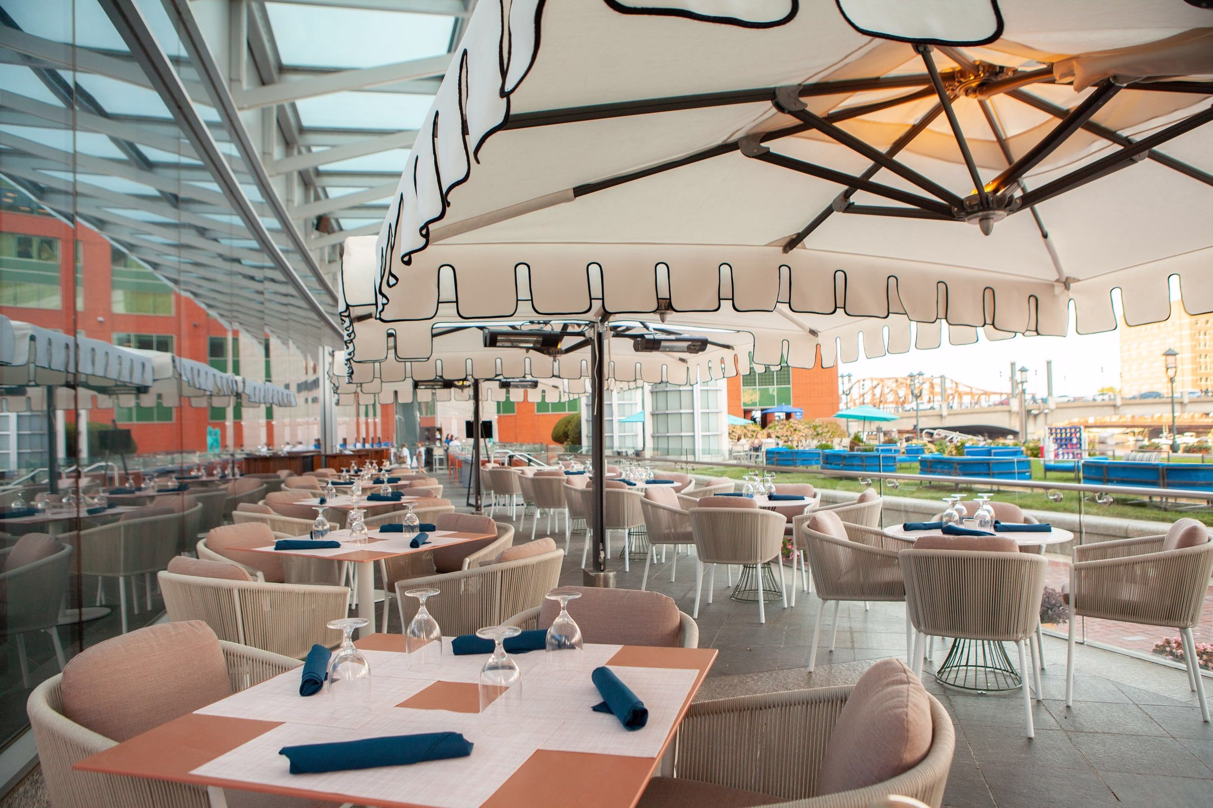InterContinental Boston Piedmont restaurant waterfront patio with white striped umbrellas and harbor breeze
