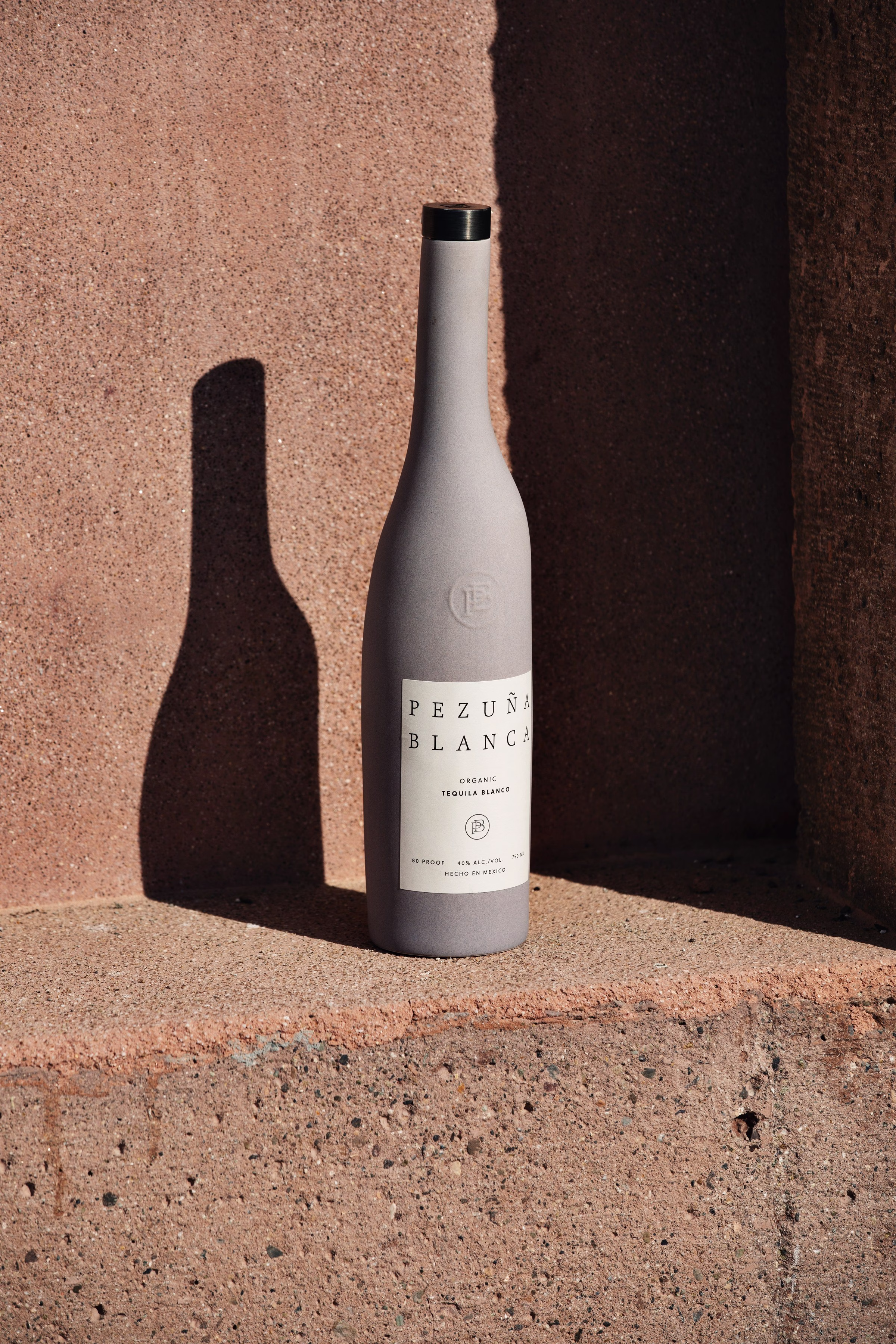 Pezuna Blanca Blanco tequila concrete-finish bottle photographed in modernist styling