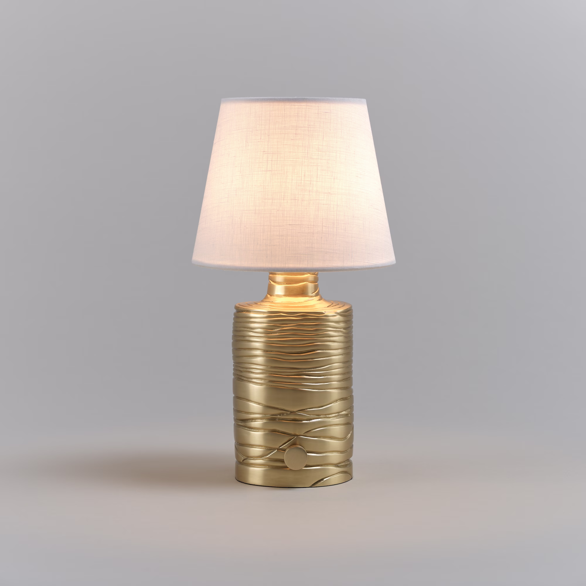 Vaughan Designs Baybridge brass table lamp illuminated against a deep backdrop